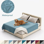 Dog lying on a bed with a waterproof mattress cover, showing water droplets on the fabric.